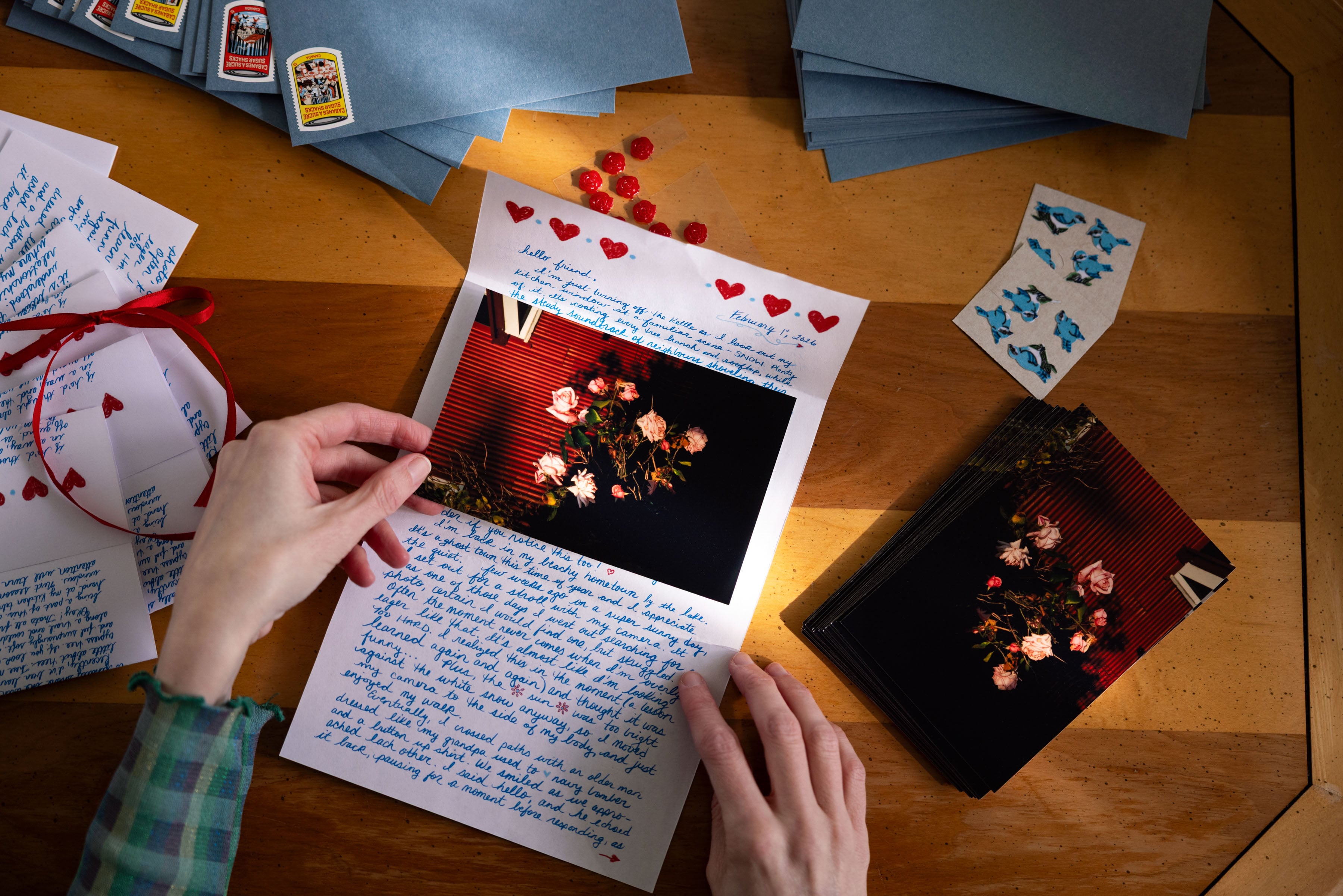 Two hands holding a handwritten note with hearts at the top of the piece of paper